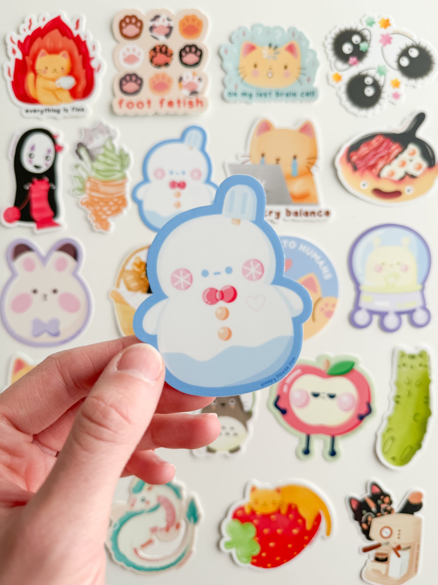 Collection of colorful stickers featuring various designs held by a hand.
