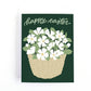 Greeting card with a basket of white flowers and 'Happy Easter' text on a green background