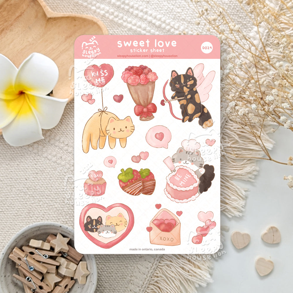 Sticker sheet with cute heart and cat illustrations on a textured surface with flowers and wooden items.